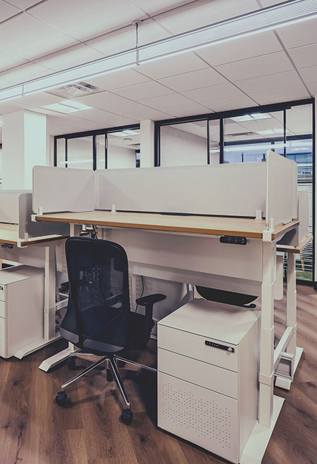 Adjustable dedicated workstation with chair and filing cabinet at Cowork by RSD.